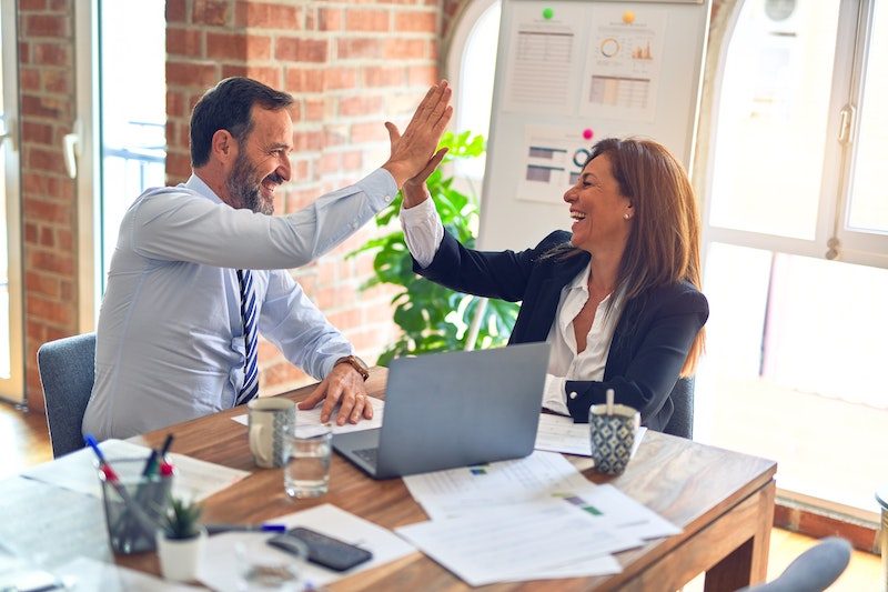 Office colleagues high fiving - Photo by krakenimages on Unsplash