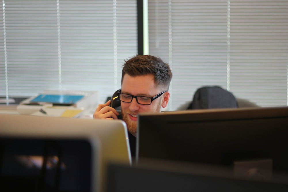 Man smiling on the phone - Photo by Berkeley Communications on Unsplash